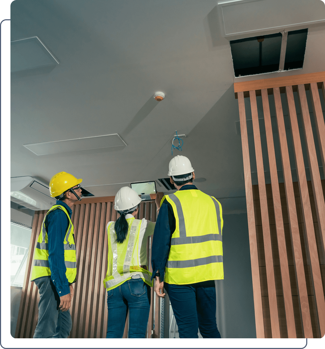 Workers assessing ceiling safety features